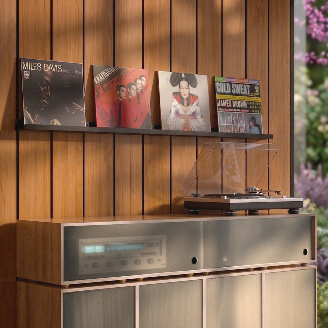 Wooden shelf with vinyl records and a turntable against a wooden wall.